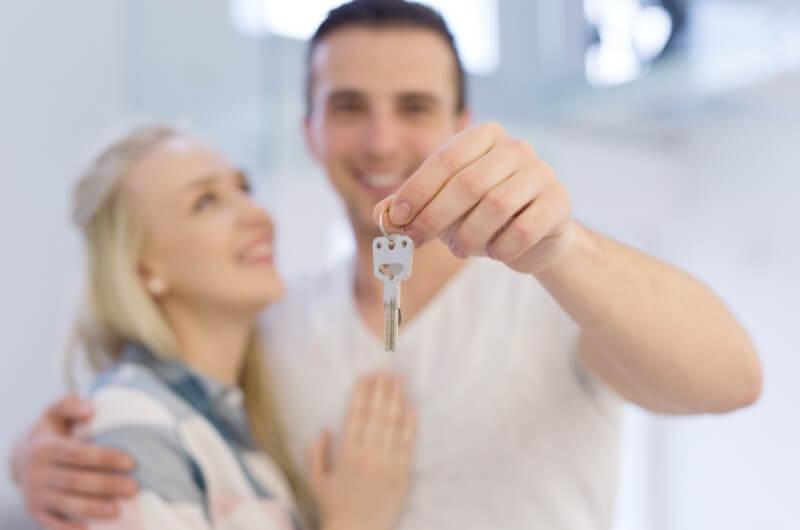 Como limpar o nome negativado | Foto de um casal sorridente segurando as chaves da casa própria | Trilha da Conquista | Blog da Tenda