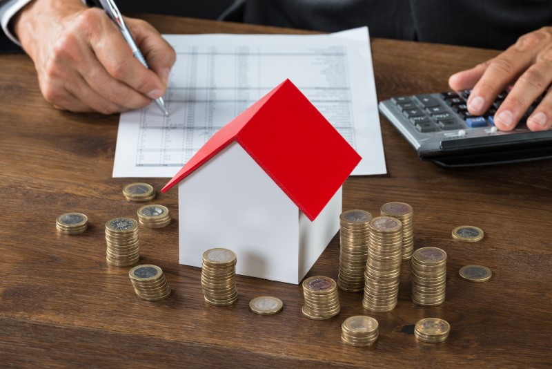 Foto de um homem calculado valor de uma casa com moedas | O que é subsídio habitacional | Guia da Tenda | Blog da Tenda