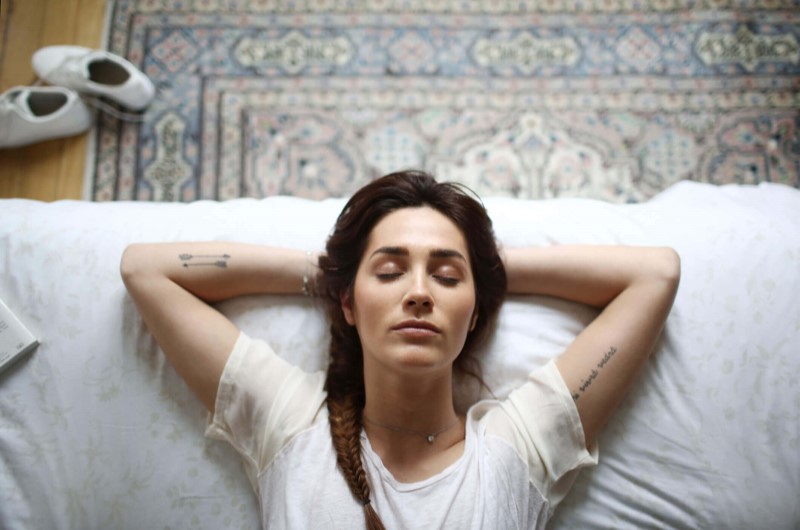 Foto de uma Mulher descansando na cama | Lei do silêncio horário | Morar em condomínio | Blog da Tenda