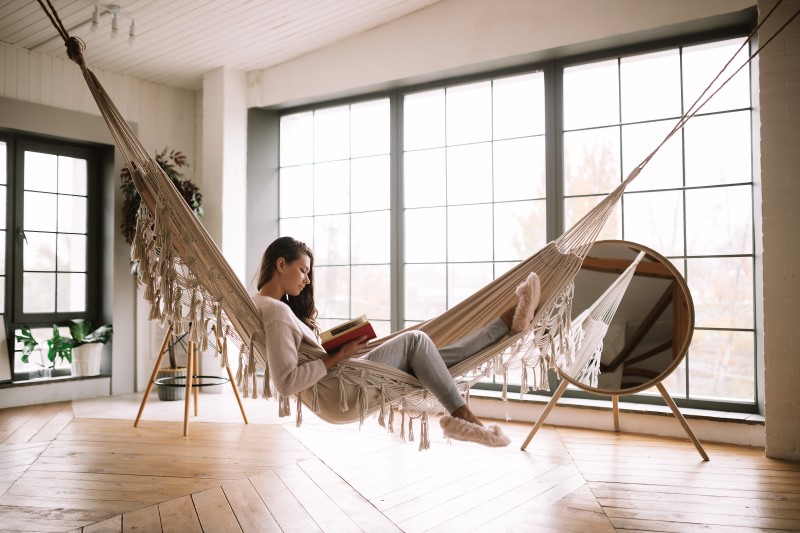 Mulher lendo na rede na sala de estar | Blog da Tenda