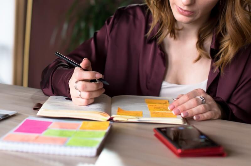 Dicas para montar um cronograma fácil de limpeza doméstica | Foto de uma mulher fazendo anotações em uma agenda | Casa e Decoração | Blog da Tenda