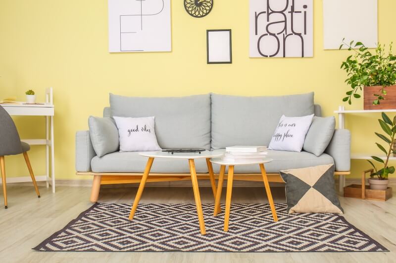 Foto de uma sala com parede amarela e sofá cinza | Pantone 2021 | Decoração | Blog da Tenda