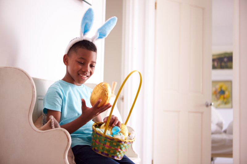 Foto de uma criança feliz com orelhas de coelho segurando ovos de chocolate | Casa e Decoração | Blog da Tenda