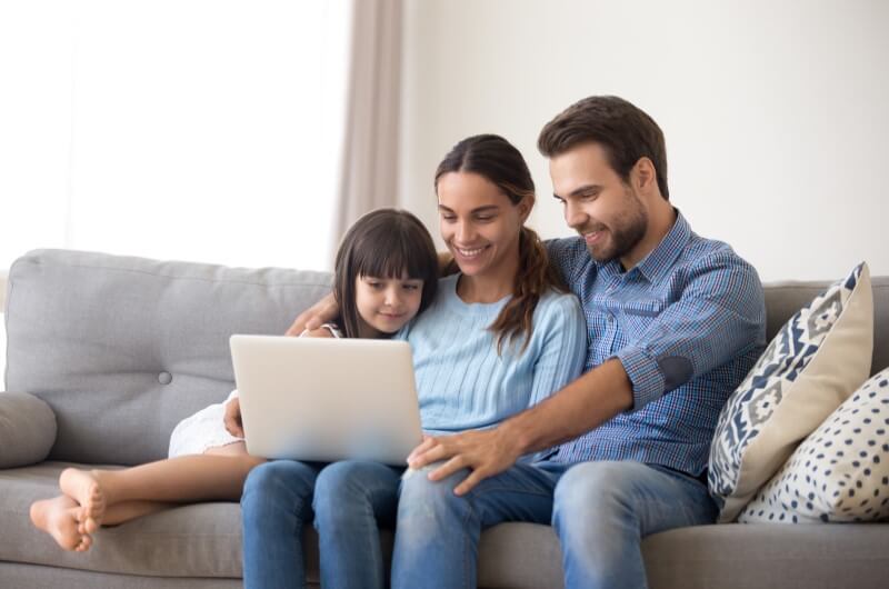 Homem, mulher e criança olhando para tela do notebook | Comprar apartamento online | Blog da Tenda