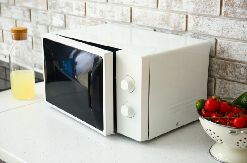 Micro-ondas | Foto de um micro-ondas branco sobre uma bancada na cozinha | Tenda explica | Blog da Tenda