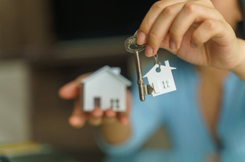 Como financiar um imóvel pelo Casa Verde e Amarela | Foto de uma pessoa segurando uma casinha e chaves | Minha Casa Minha Vida | Blog da Tenda