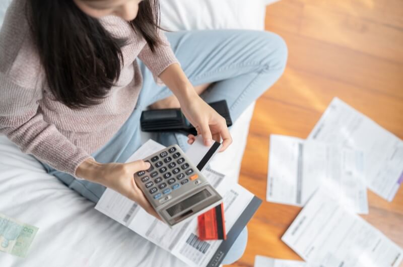Como comprovar renda no financiamento imobiliário | Foto de um mulher calculando as contas na calculadora | Guia da Tenda | Blog da Tenda