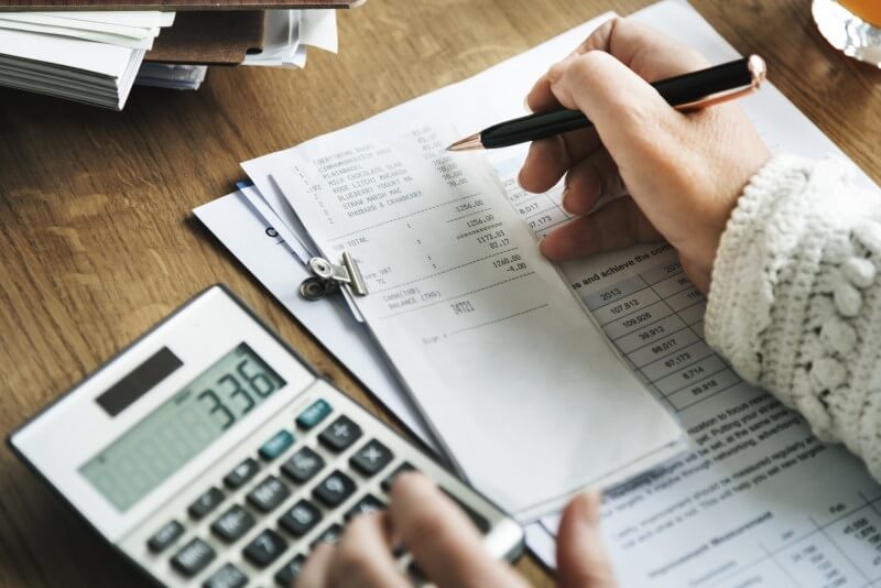 Quais documentos são aceitos no financiamento imobiliário | Foto de uma pessoa calculando as contas | Guia da Tenda | Blog da Tenda