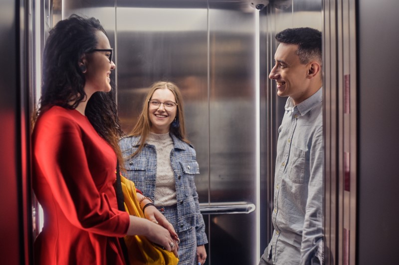 Quais são as regras para o uso de elevador de condomínio | Foto de pessoas conversando no elevador | Blog da Tenda