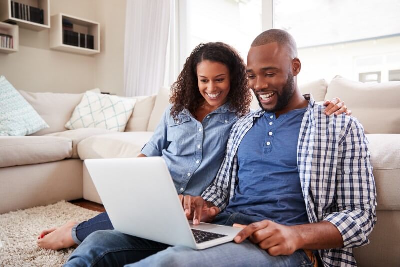 Foto de um casal negro feliz comprando na internet | Como declarar imóvel em conjunto no IR | Guia da Tenda | Blog da Tenda
