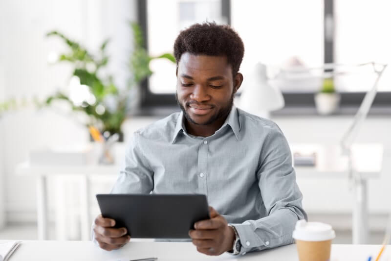 Foto de jovem negro pesquisando no tablet | Tudo sobre IPTU | Blog da Tenda