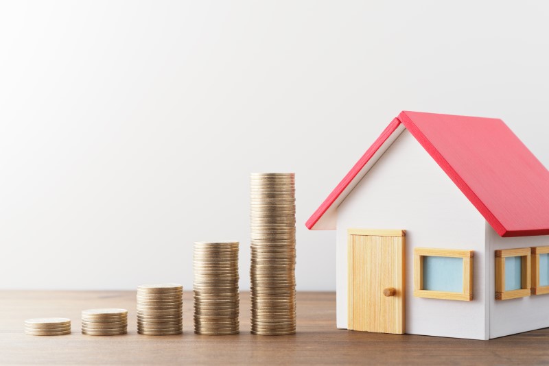 Foto de uma casinha e uma escada de moedas | Quais são os tipos de financiamento de imóveis | Guia da Tenda | Blog da Tenda
