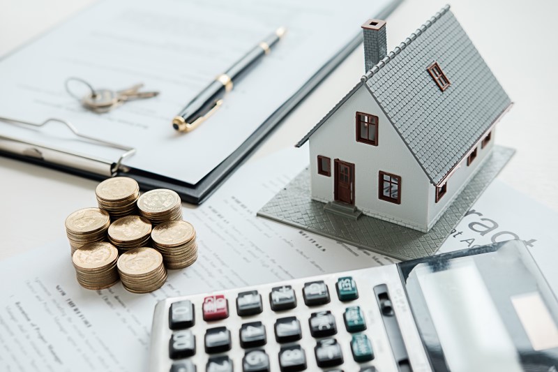 Foto de calculadora, dinheiro, contrato e uma casa | Como fazer amortização de financiamento | Guia da Tenda | Blog da Tenda