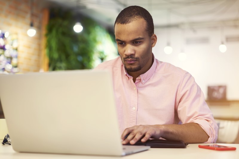 Foto de um jovem negro pesquisando no computador | Como comprar um apartamento sozinho | Guia da Tenda | Blog da Tenda
