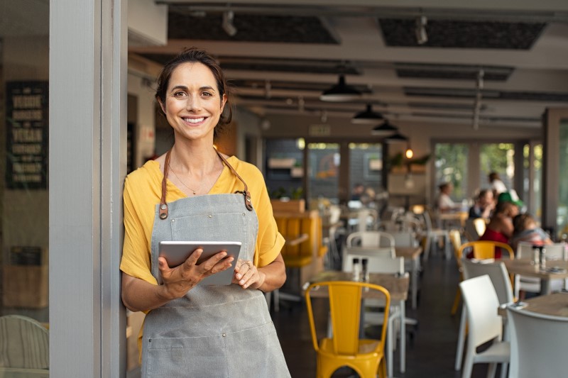 Foto de uma mulher trabalhando num restaurante | Como comprar um apartamento com salário mínimo | Guia da Tenda | Blog da Tenda
