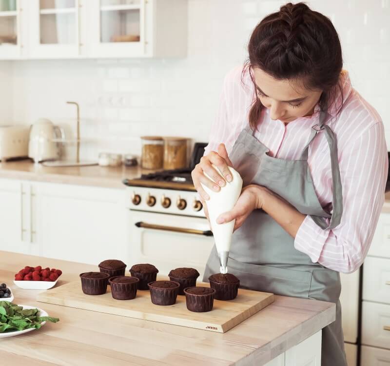 Foto de uma mulher fazendo cupcakes | Como fazer renda extra | Economize | Blog da Tenda 