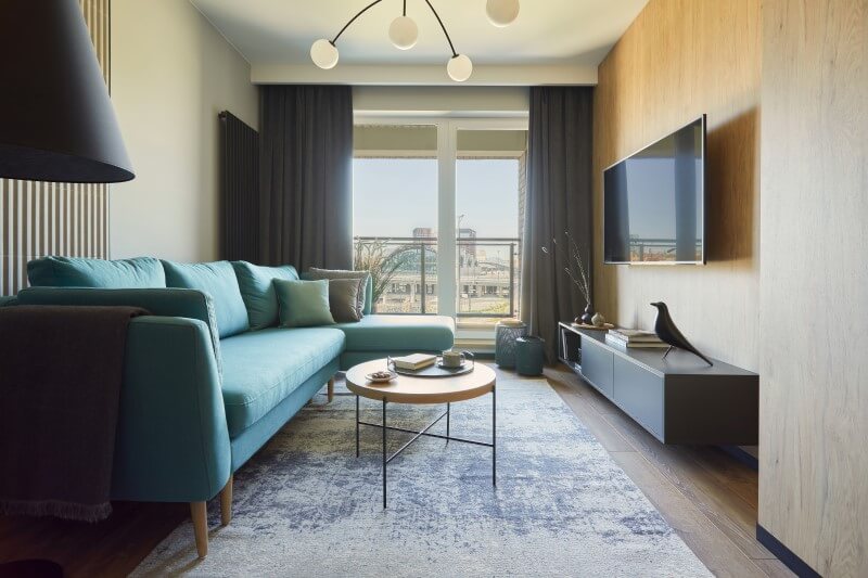Foto de uma sala de estar de apartamento pequeno com painel de tv | Marcenaria planejada para imóvel compacto | Blog da Tenda