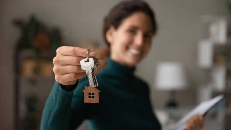 Foto de uma mulher segurando as chaves de uma casa | O que acontece depois da entrega de chaves de um imóvel | Guia da Tenda | Blog da Tenda