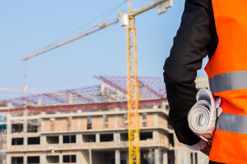 Foto de um homem olhando construção de um prédio | O que é taxa de evolução de obra | Guia da Tenda | Blog da Tenda