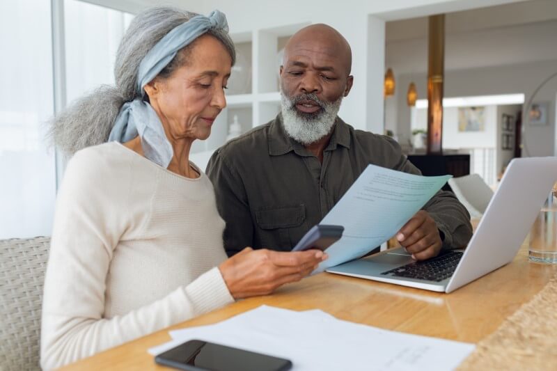 Foto de casal de idosos negros fazendo as contas | Qual idade máxima para financiar um apartamento | Guia da Tenda | Blog da Tenda 