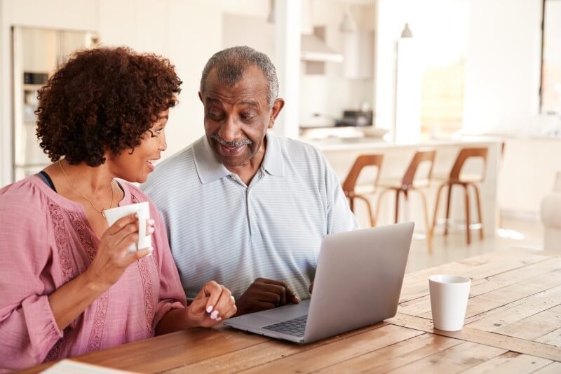 Foto de pai e filha negros conversando em casa | Quais são as regras para idoso financiar imóvel | Guia da Tenda | Blog da Tenda