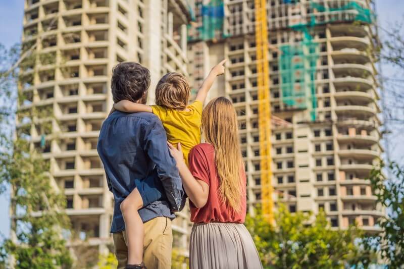 Foto de uma família olhando construção de um prédio | Dicas para comprar um imóvel | Guia da Tenda | Blog da Tenda