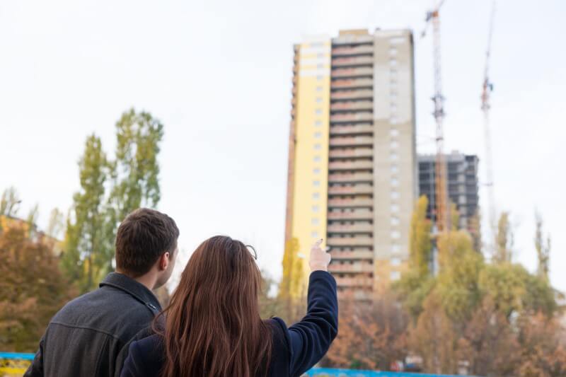 Foto de um casal olhando construção de um prédio | Dicas para comprar um imóvel na planta | Guia da Tenda | Blog da Tenda 