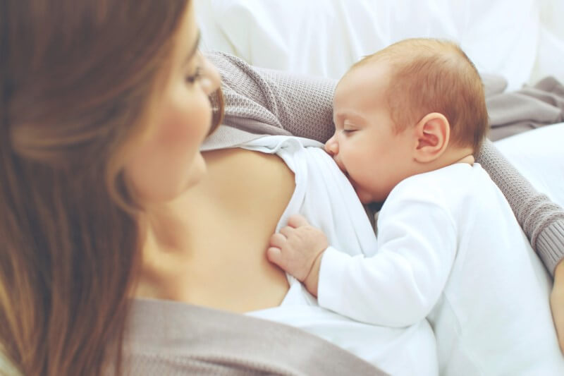 Foto de uma mulher amamentando um bebê | Programa de gestantes e sala de lactantes Tenda | Jeito Tenda de ser | Blog da Tenda