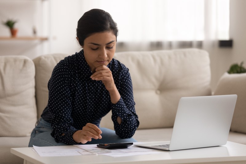 Foto de uma mulher preocupada calculando as contas | Quais são os documentos para comprovar renda | Guia da Tenda | Blog da Tenda