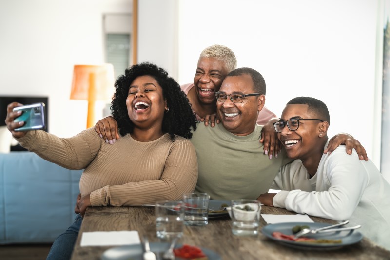 Foto de uma família negra feliz tirando uma selfie | Como ter um bom relacionamento com os pais depois que sair de casa | Guia da Tenda | Blog da Tenda