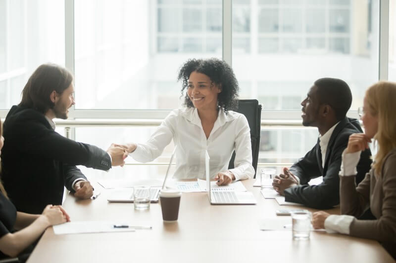 Foto de uma mulher negra em uma reunião com equipe | Como trabalhar a melhoria contínua de um líder | Jeito Tenda de ser | Blog da Tenda