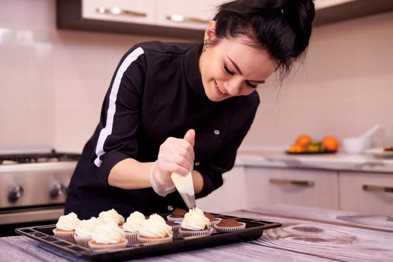 Foto de uma mulher fazendo cupcakes | Como fazer uma renda extra para comprar um apartamento sozinha | Guia da Tenda | Blog da Tenda