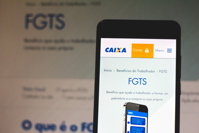 Como usar o FGTS para comprar apartamento | Foto de um celular e um computador com o logo do FGTS | Guia da Tenda | Blog da Tenda 
