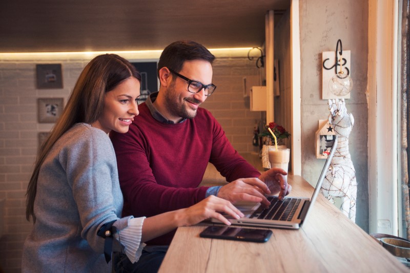 Foto de um casal feliz pesquisando na internet | Como comprar um apartamento | Guia da Tenda | Blog da Tenda