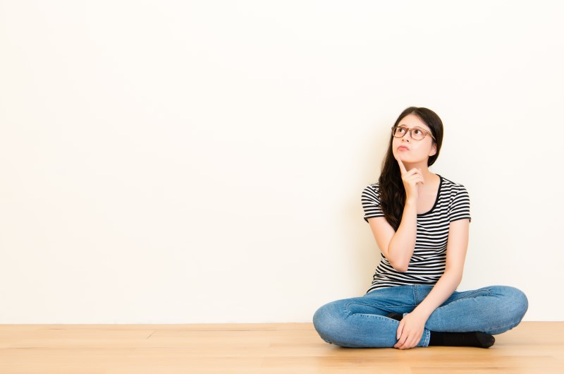 Comprar um imóvel: 5 mitos sobre o assunto | Foto de uma garota sentada no chão pensativa | Guia da Tenda | Blog da Tenda