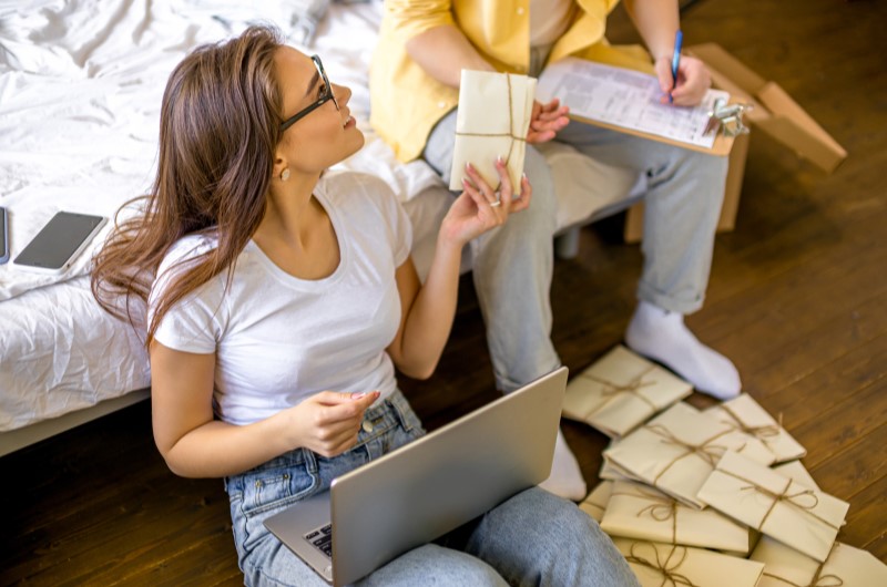 Faça a lista de convidados | Foto de um casal feliz organizando os convites do casamento | Economia e renda extra | Eu Dou Conta