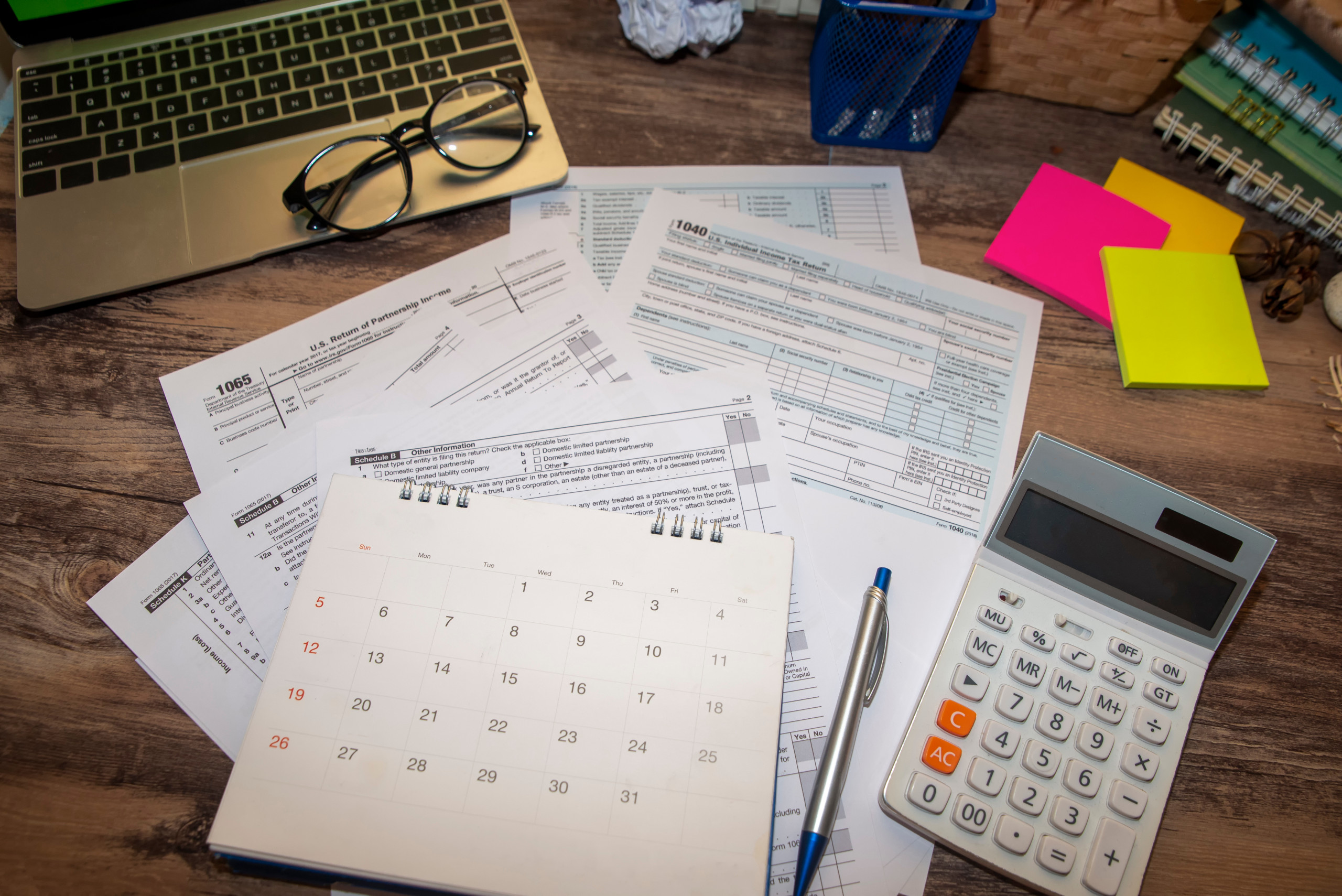 Quais são as vantagens de quitar o saldo devedor? | Foto de diversos papeis, notebook e calculadora | Trilha da Conquista | Blog da Tenda