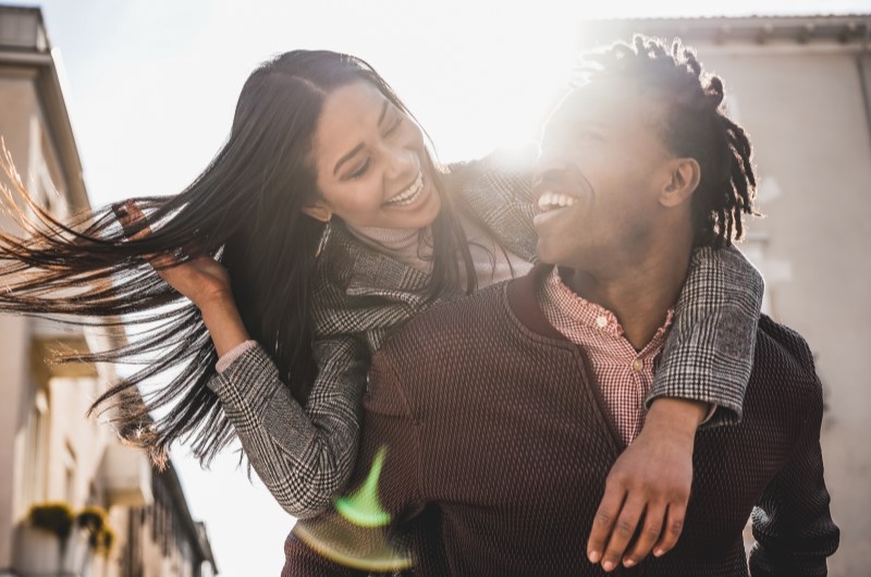 Passeios baratos: lugares para visitar em Curitiba | Foto de um casal sorridente, passeando em um dia ensolarado | Eu Dou Conta | Blog da Tenda 