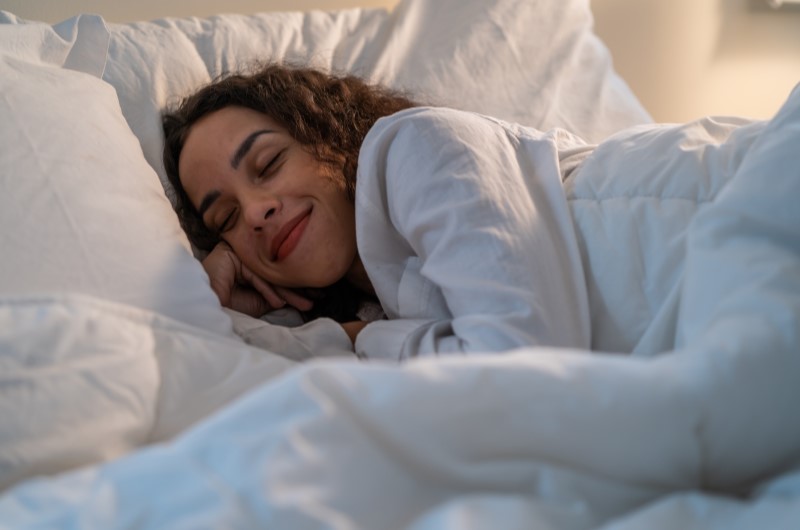 Qual o nível de decibéis permitido por lei? | Foto de uma moça dormindo na cama | Viver em Condomínio | Blog da Tenda 