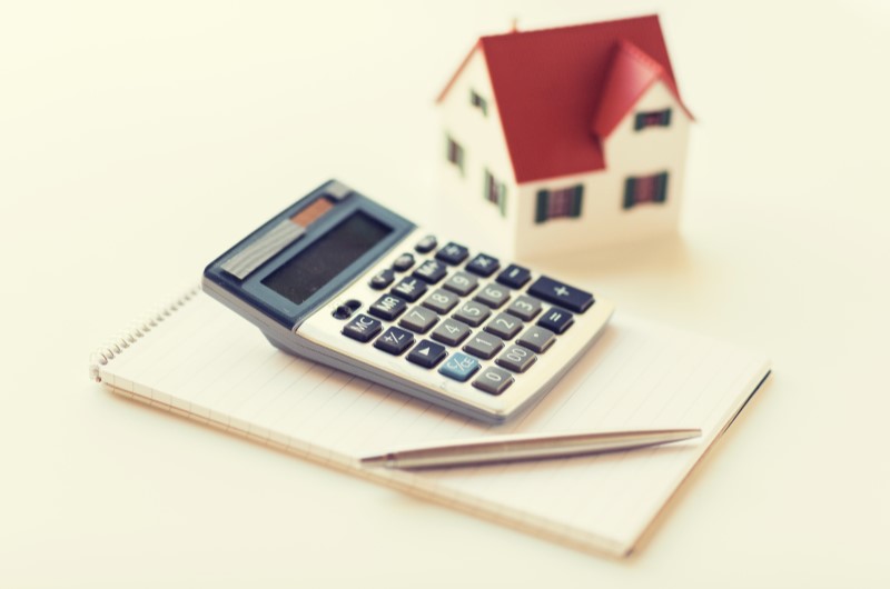 Taxa de juros do Minha Casa Minha Vida | Foto de uma casinha e uma calculadora sobre uma agenda | Minha Casa Minha Vida | Blog da Tenda 