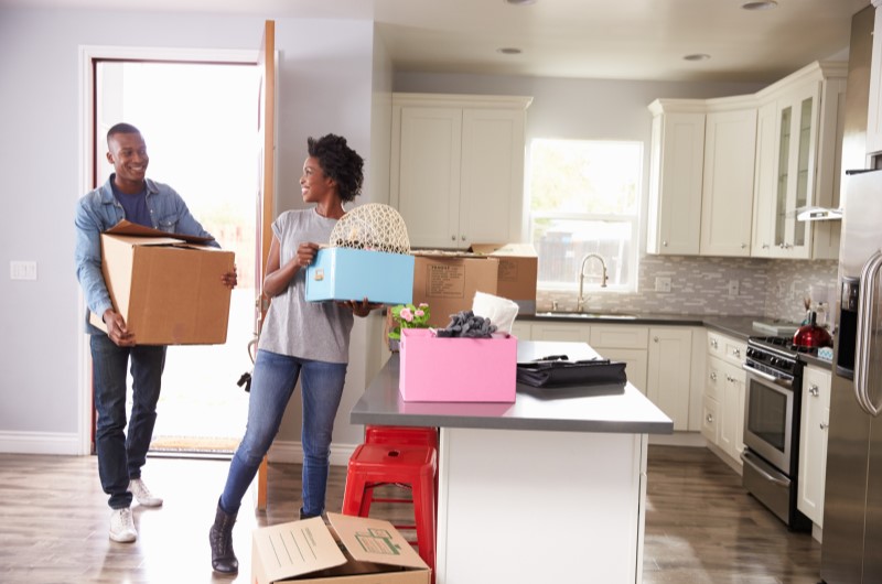 Como economizar ao comprar itens para a casa nova | Foto de um casal segurando caixas de mudança para a casa nova | Casa e Decoração | Blog da Tenda