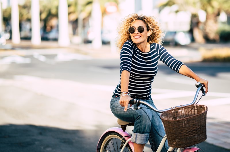 Ciclovias | Foto de uma moça sorridnete andando de bicicleta | Trilha da Conquista | Blog da Tenda