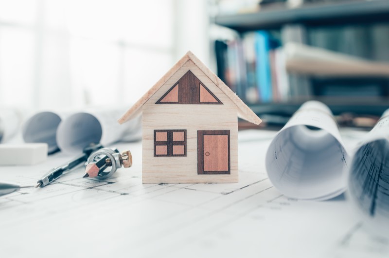 Como financiar um apartamento na planta? | Foto de uma casinha sobre uma planta de imóvel | Trilha da Conquista | Blog da Tenda