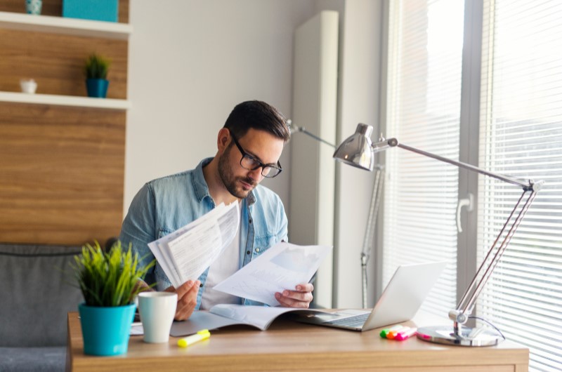 Documentos necessários | Foto de um homem concentrado em olhar alguns documentos | Blog da Tenda