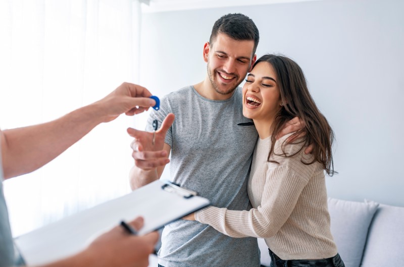 Escolha o tipo de financiamento ideal para você | Foto de um casal sorridente recebendo as chaves da casa própria | Trilha da Conquista | Blog da Tenda