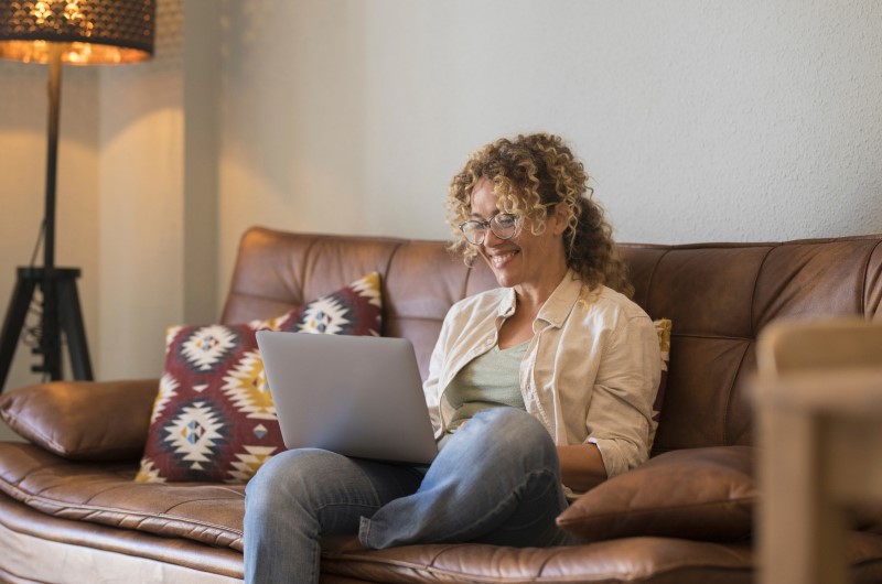 Jardim Gilda Maria | Foto de uma moça sentada no sofá da sala e usando o notebook | Trilha da Conquista | Blog da Tenda