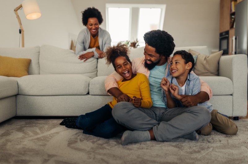 Melhor aproveitamento do espaço | Foto de uma família feliz se divertindo na sala de estar | Casa e Decoração | Blog da Tenda