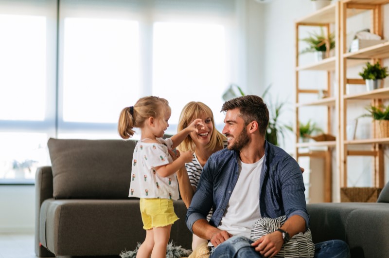 Por que as pessoas escolhem morar na Zona Oeste de São Paulo? | Foto de uma família se divertindo na sala de estar | Trilha da Conquista | Blog da Tenda