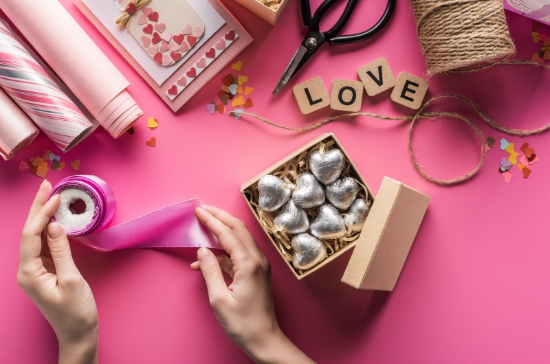 Ideias de presentes "faça você mesmo" para o Dia dos Namorados | Foto de uma pessoa fazendo o embrulho de um presente de dia dos namorados | Economia e renda extra | Eu Dou Conta