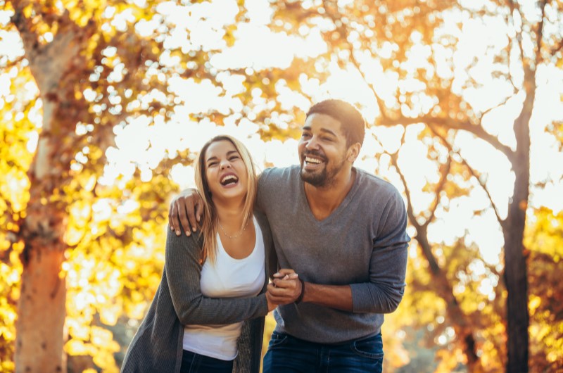 Praça dos Mártires | Foto de um casal sorrindo enquanto caminha em um parque | Trilha da Conquista | Blog da Tenda